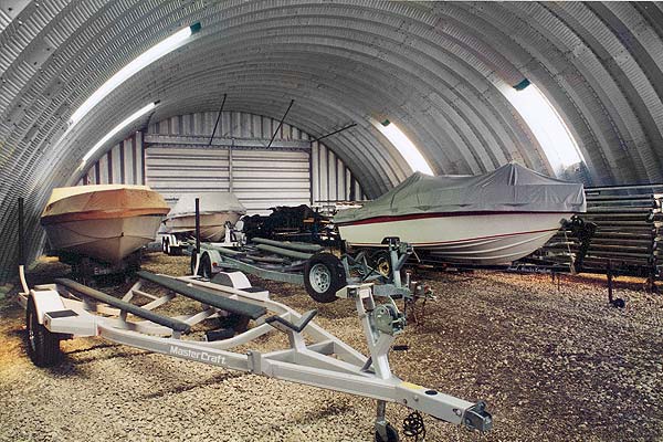 large inside view of an arch style steel building with two boats fit inside 