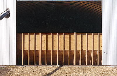 showing the bulkhead in front of the door of the building prevents grain from reaching the door.