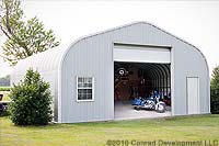 a grey metal garage kit with a white garage door. 