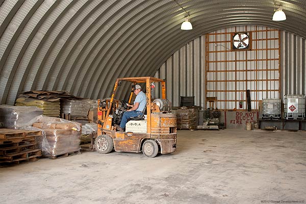 large inside view of an arch style steel building with two boats fit inside 